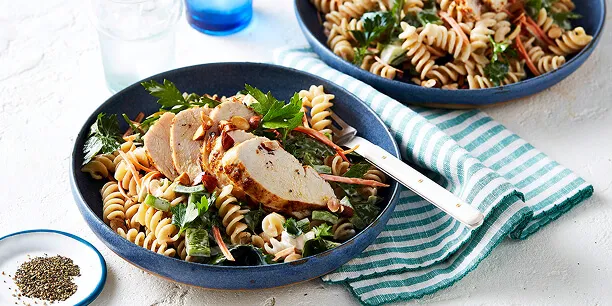 Pasta salad with sliced grilled chicken, and fresh greens: a Total Wellbeing Diet meal.